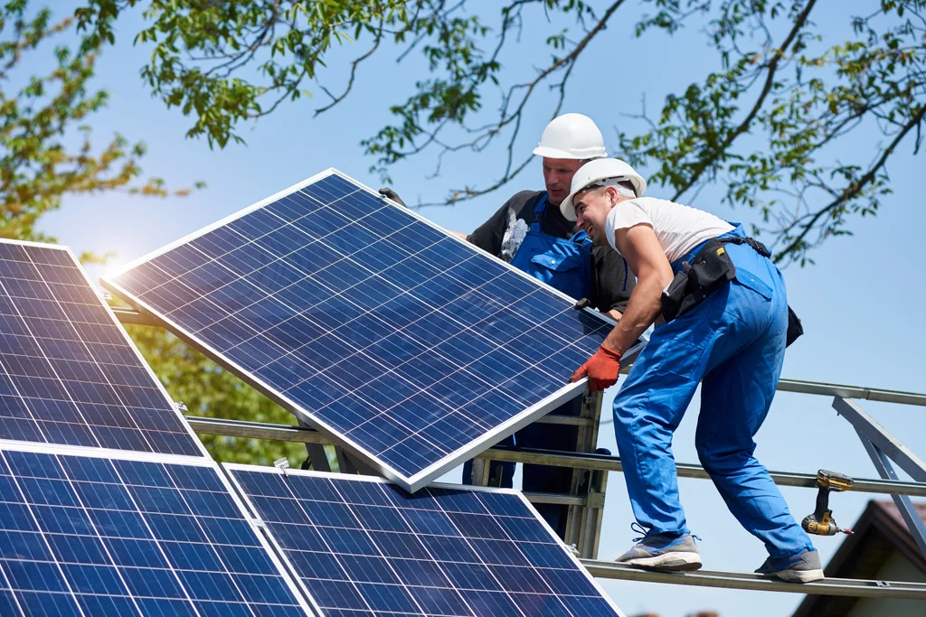 stock-photo-two-young-technicians-mounting-heavy-solar-photo-voltaic-panel-tall